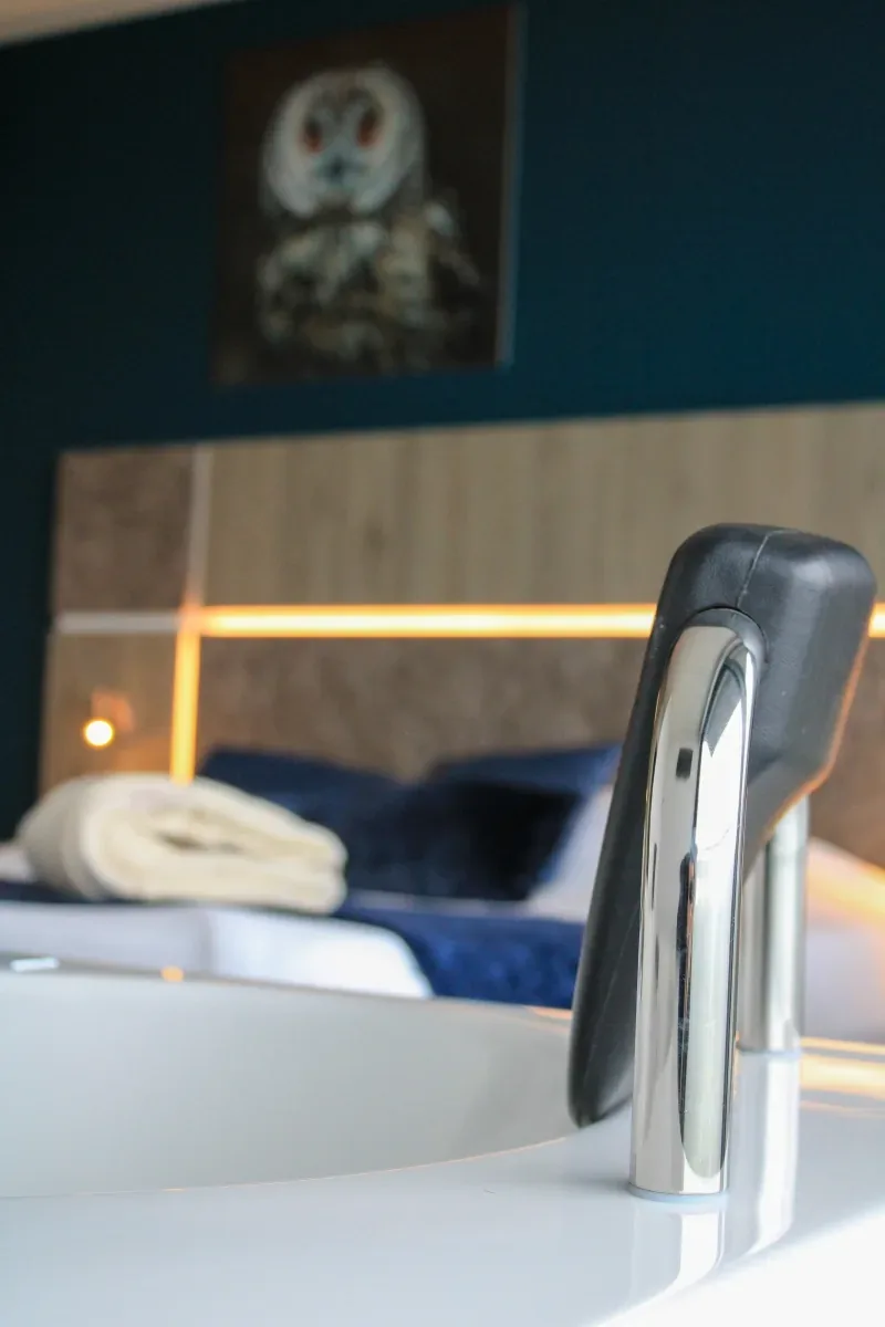 A bedroom in deep blue with towels folded on the bed
