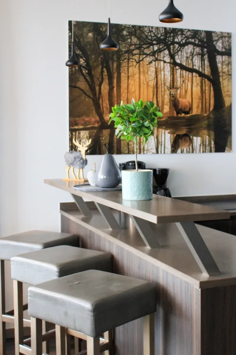 The kitchen bar with stools, a stag print on the wall behind