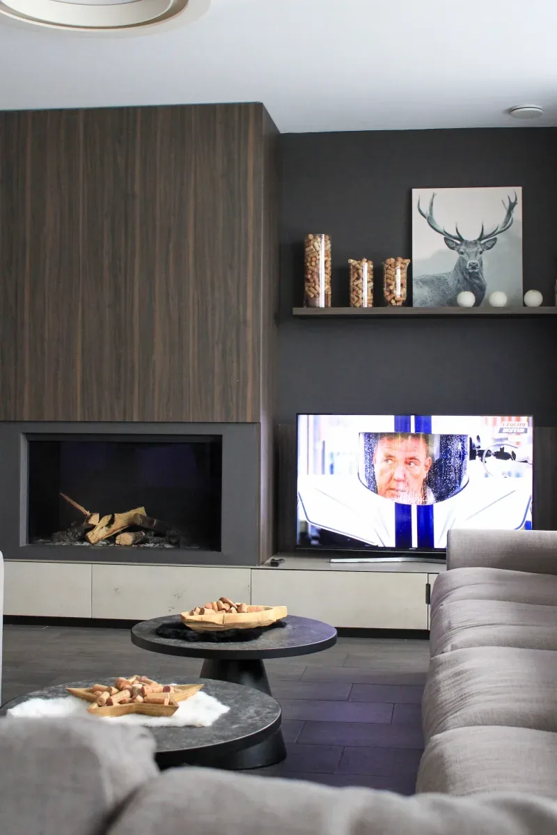 The lounge with a gas fire lit and a flatscreen above